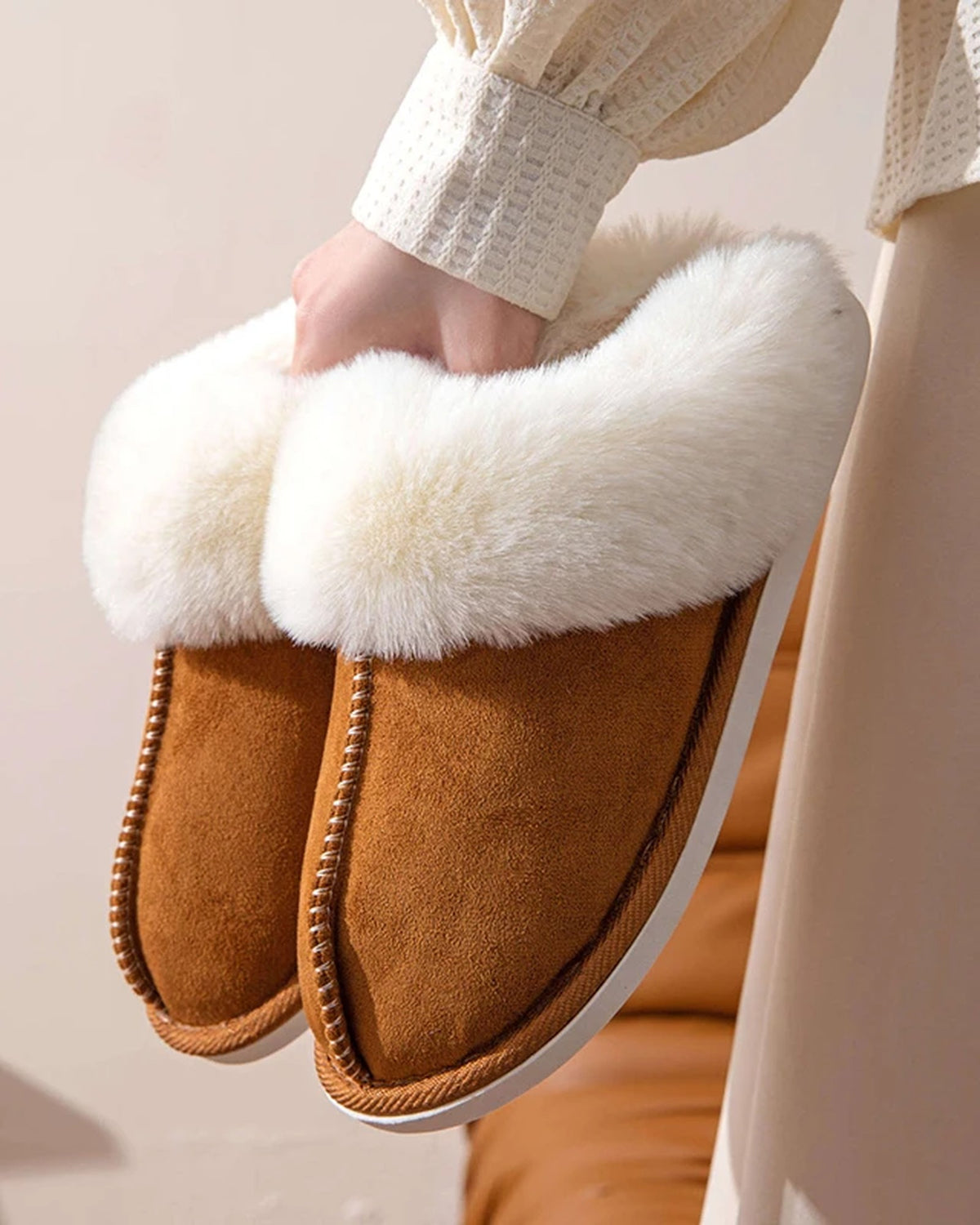 Chestnut faux suede scuff slippers held in hand