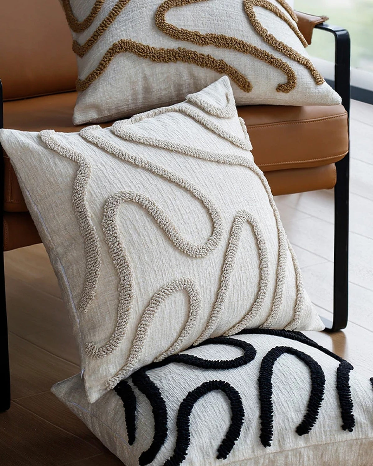 Tufted wavy-line cushion covers stacked on an armchair