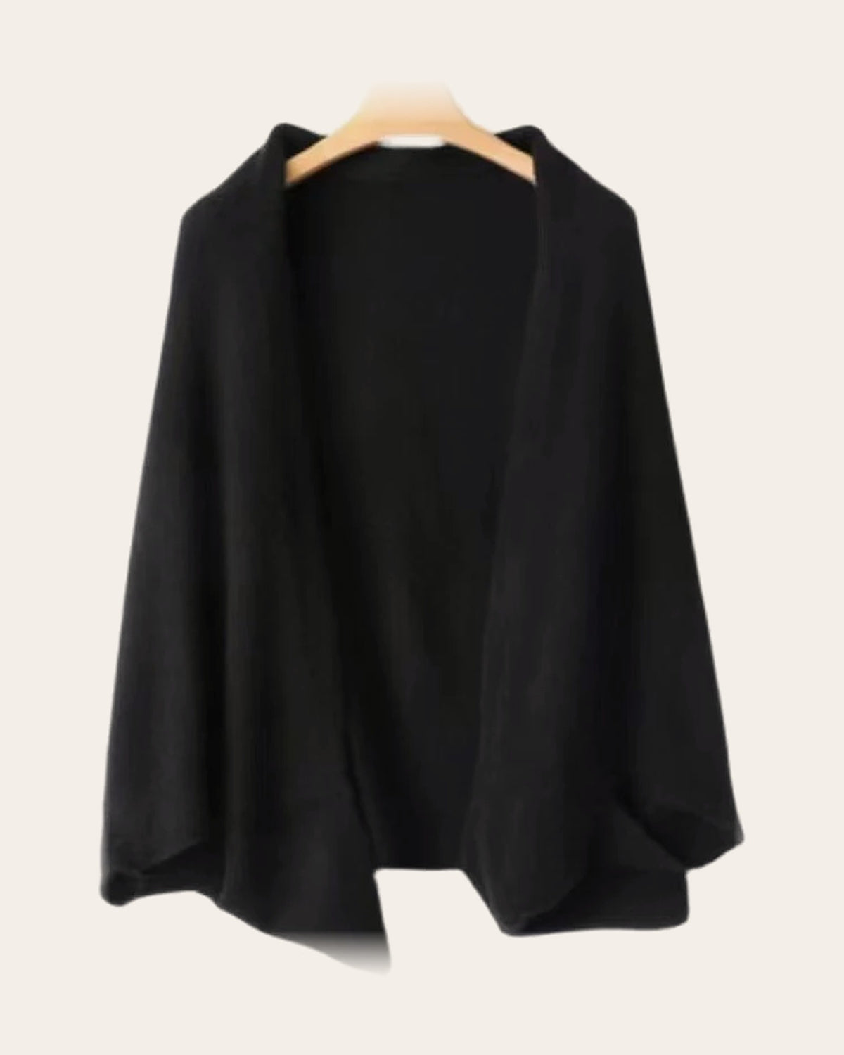 The Mabel Knit Wrap in Black on a hanger