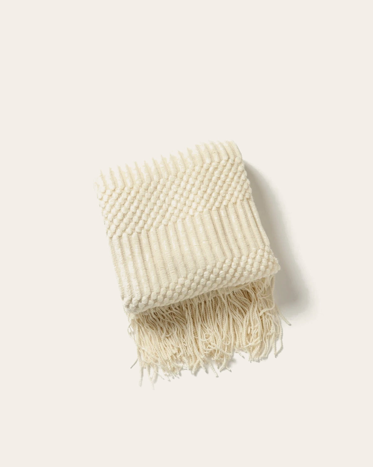 The Elsie Knitted Throw in Cream, folded